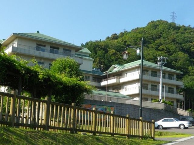 青空と建物の外観 外観 自然に囲まれた落ち着いた環境で、清々しい空気の中で働くことができます。