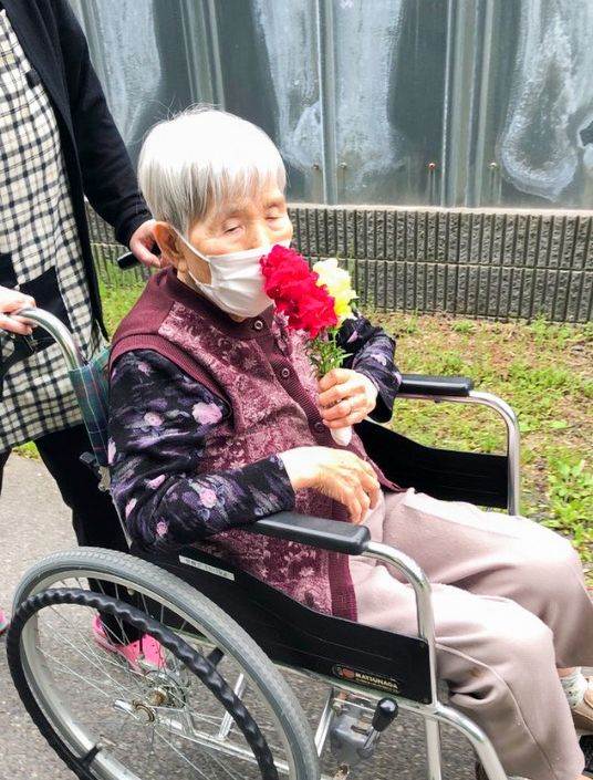 車椅子の方とスタッフ中庭