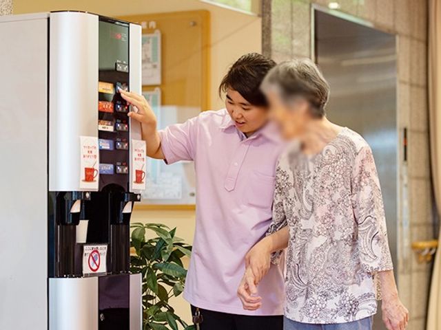 人と自販機の様子 内観 スタッフが寄り添い、安心して利用できる環境です。自販機の使い方も丁寧に説明します。