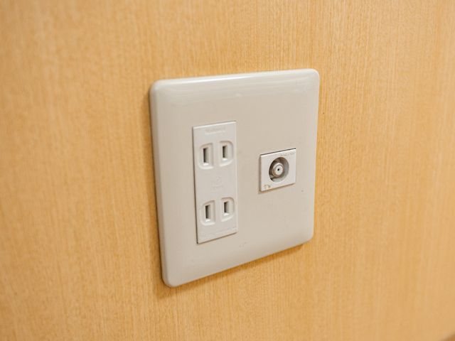 壁の電源端子 内観   木目調の壁に、電源とテレビ端子がすっきりまとめられています。設備が整った落ち着いた空間で、働く環境をイメージしやすいです。