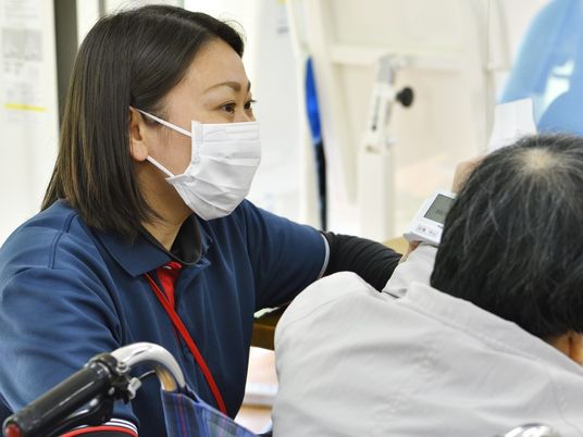 介護士が利用者を測定する場面  