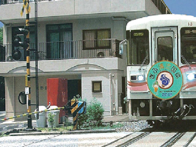 電車通過の風景 外観 施設の前には鉄道の線路があり、電車が通過する様子が見られます。