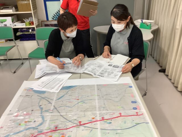 記録を確認する職員の多目的室 多目的室   机を囲んで資料を広げ、職員同士が確認作業をしています。打ち合わせや記録整理に使いやすい空間です。