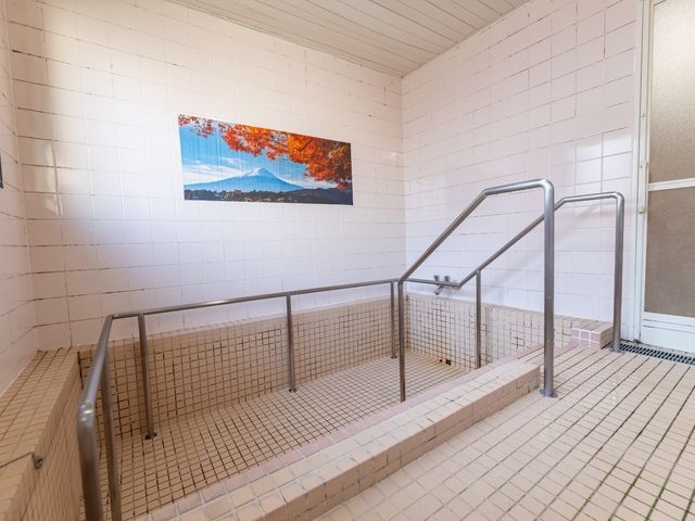 浴室の手すり付き浴槽 浴室 手すりが設置された浴槽は安全に配慮され、壁には季節の美しい景色が飾られています。