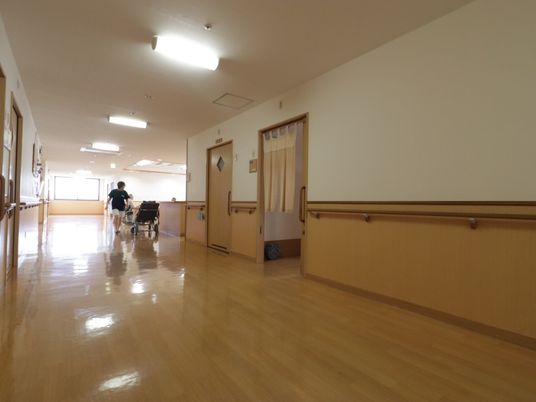  廊下に人と車椅子  