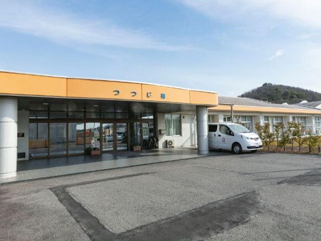 入り口がある建物外観 外観 緑の多い環境に位置する建物で、落ち着いた雰囲気の中で就業できます。