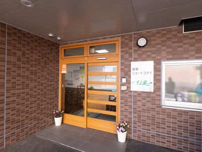 玄関の木製扉と植物