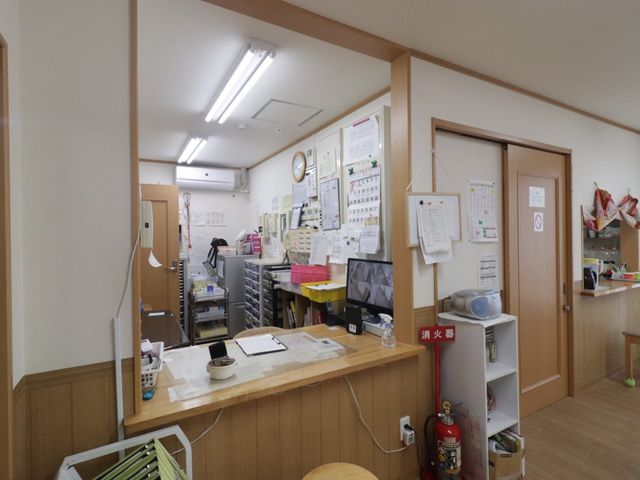 スタッフルームの様子 スタッフルーム 綺麗に整理されたスタッフルームが広がり、情報交換に便利な掲示板とキッチンエリアも見えます。チームワークを育む環境が整っています。