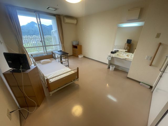 ベッドのある居室 居室 大きな窓から自然光が差し込み、明るく開放的な居室です。必要な設備が整っており、快適に過ごせます。