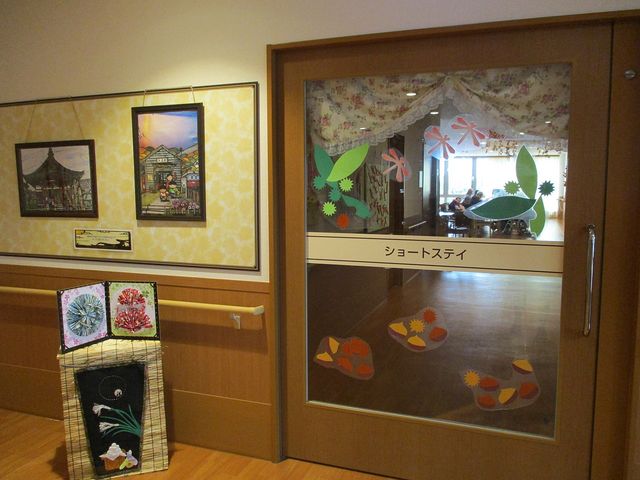 飾りが施された入口 多目的室 手作りの飾りが楽しめる木製の扉が、温かみを感じさせるアプローチです。多目的に利用できるスペースですので、様々な活動に参加しやすい環境になっています。