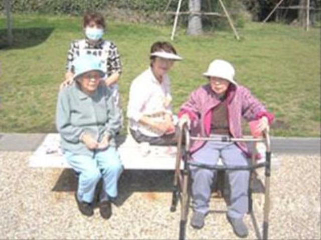 笑顔のお年寄り中庭 ボランティア ゆったりとした中庭で、スタッフと共に楽しいひと時を過ごす利用者様の姿。自然光あふれる環境は、充実した日々を約束します。