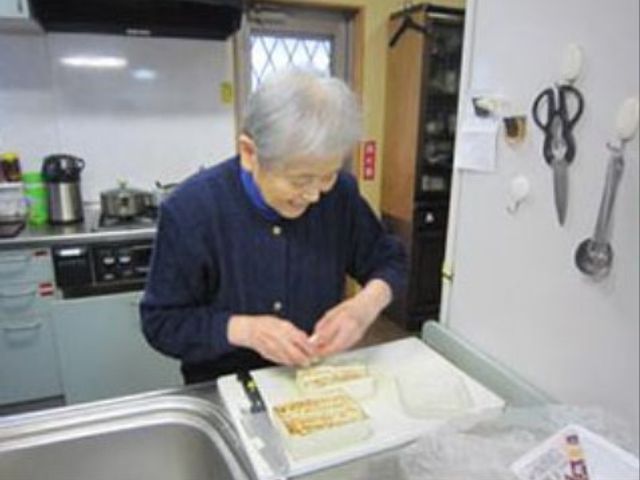 利用者が調理を楽しむキッチン サポート 笑顔で調理に取り組む姿が見られる、家庭的な雰囲気のキッチンです。利用者が自分のペースで日常生活を営むことができる環境を大切にしています。