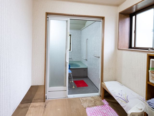 居室の入り口と浴室 脱衣所 ゆとりのある居室から連なる洗浄機能付き浴室です。バリアフリー設計で快適な入浴が実現します。