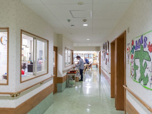 清潔な広い廊下 廊下 手すりが設けられた廊下は、清掃が行き届き、作業をされている職員の姿も見受けられます。安全かつ快適な環境でのお仕事ができます。