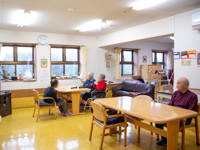 光溢れる居室 共用リビング ゆったりとしたソファやテーブルが配置され、利用者同士がくつろぎながら交流できる居室です。窓からは自然光があふれ、暖かい雰囲気が漂っています。