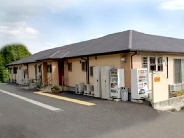 一階建ての建物外観 外観 一階建てで、敷地内には自動販売機が設置された、清潔感のある建物です。ゆったりとした歩道もあり、働く環境としても快適です。