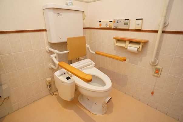 バリアフリー完備で、壁に手すりが設置されているトイレ