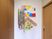 サムネイル 施設の写真 玄関を入った正面の壁に、鮮やかな折り紙で作られた千羽鶴と絵が飾られている。色紙の台紙には入居者様のお写真が貼られている。