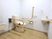 サムネイル 施設の写真 木目調のベージュの床と白い壁の広いトイレがある。壁には手すりがあり、便座にはひじ掛けがある。同じ室内には洗面台がある。
