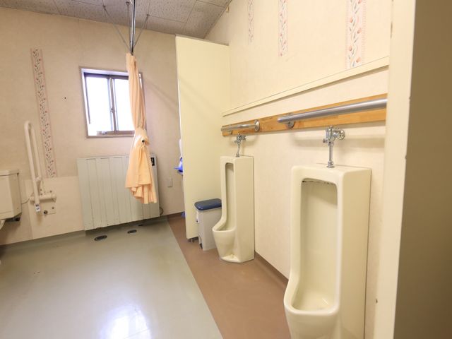バリアフリートイレ設備 男性用トイレ 手すり付きの安全なトイレ空間です。利用者の安全と自立を支援する配慮がされています。