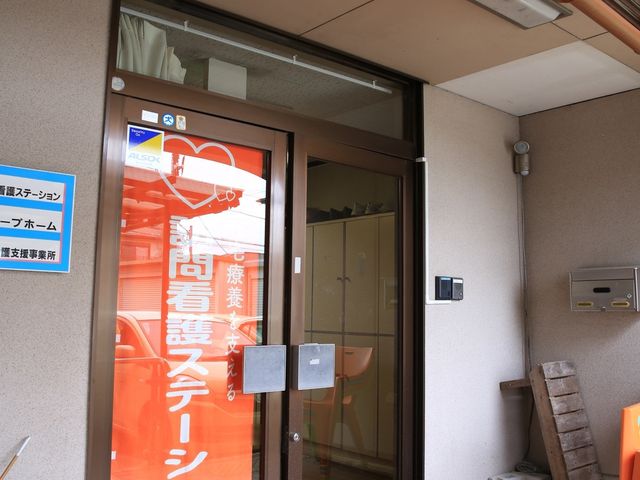 明るいエントランスの自動ドア 玄関 自動ドアでアクセスしやすい清潔なエントランスです。来訪者を温かく迎える第一印象を大切にしています。