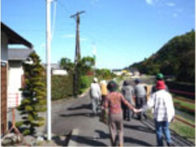 利用者の散歩風景 散歩 ゆったりとした道を利用者が歩いている様子です。共に時を過ごす仲間との散歩は心の潤いをもたらします。