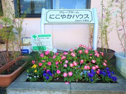 花と看板のあるエントランス