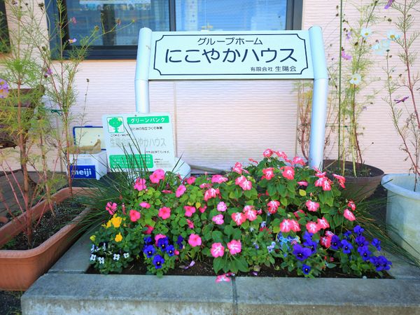 花と看板のあるエントランス