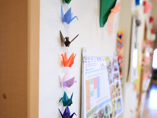 手作り折り紙の装飾 装飾 廊下に並ぶ手作りの折り紙は、訪れる人々へ温かみを感じさせ、楽しい気持ちを与えてくれます。芸術的な趣味活動が楽しめる暖かい雰囲気が漂っています。