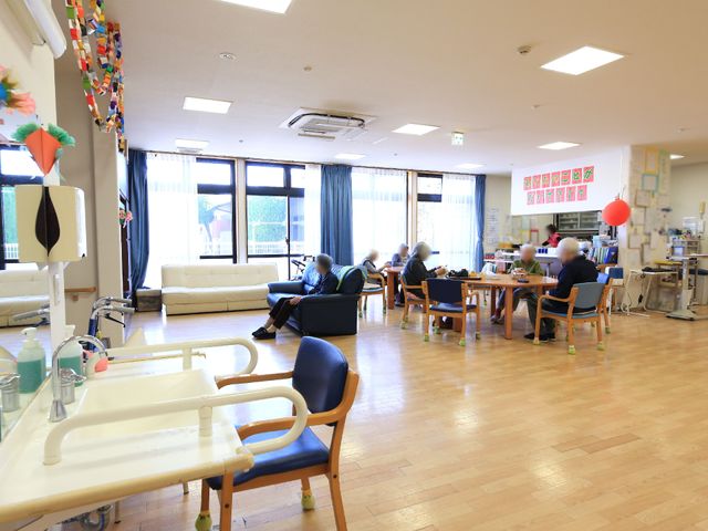 共有スペースの日常風景 リビング 明るく開放的な空間で、利用者様がリラックスしながら食事や娯楽を楽しんでいらっしゃいます。ぜひ一緒に心地よい時間を提供しませんか。