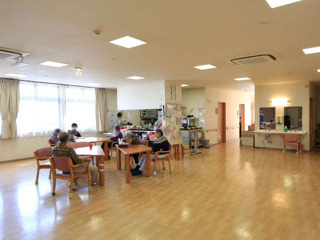 広々とした明るい食堂 リビング 開放的な空間で利用者が食事を取る食堂です。木製のテーブルや椅子が配置され、窓からは自然光が差し込んでいます。