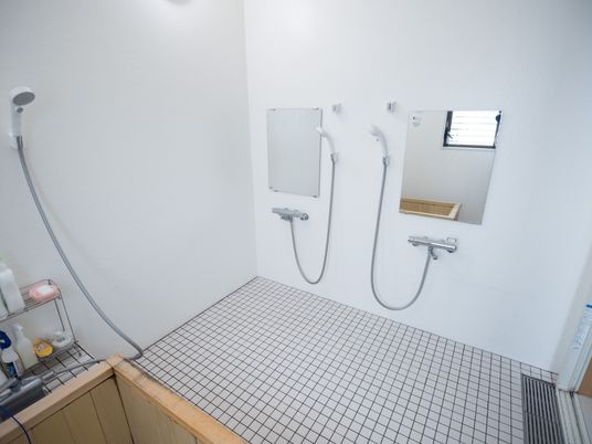 浴室は檜風呂となっている。浴槽のすぐそばにはボディーソープやシャワーがある。洗い場には鏡が２枚とシャワーが２台設置されている。