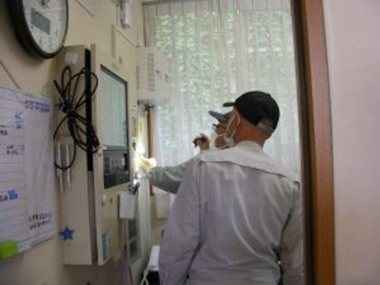 廊下で点検するスタッフ  