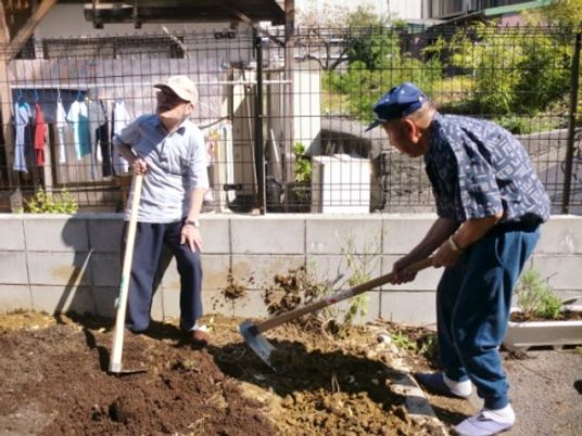 庭で土を耕す二人