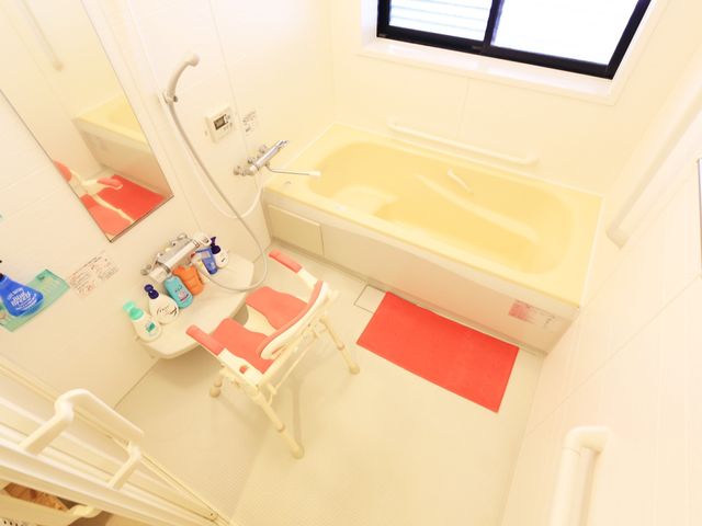 バリアフリー設計の浴室 浴室 手すりや座浴椅子を設置した安全配慮の空間。利用者の快適なバスタイムを支援します。