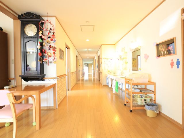 温かみのある廊下の風景 通路 床の材質に木目調を採用し、装飾品や絵画が飾られた廊下は温もりを感じさせ、訪れる人に安らぎを与えます。