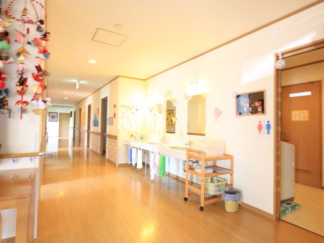 廊下の装飾と掲示物 洗面台 廊下は明るく、壁に季節の装飾が施され心地よい雰囲気です。手作りの掲示物が訪れる人々に温かみを与えています。