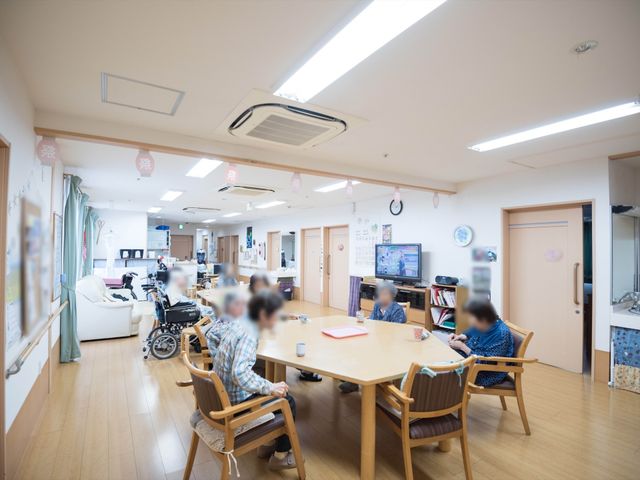 共有スペースの日常風景 食堂 ゆとりある食堂では、利用者が穏やかに過ごしており、テレビやおしゃべりでリラックスできる環境が整っています。