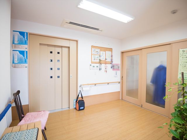 明るい廊下と扉 玄関 ゆとりある廊下と掲示物が備えられ、安全な手すりも完備しておりますので、快適にお過ごしいただけます。
