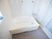 浴室内の壁と浴槽は白色で、床はグレー色である。壁には縦と横の手すりが複数備えられている。シャワーや水道の蛇口もある。
