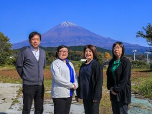 4人が並ぶ屋外の庭  