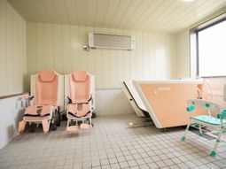 ケア用チェアと浴槽のある浴室