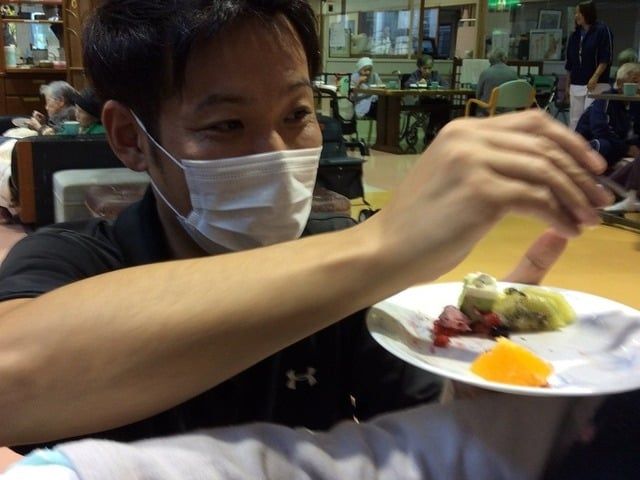 利用者に食事を配る職員 食堂 職員が利用者に食事を提供しています。穏やかな交流が見られる、和やかな空間です。