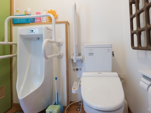 手すり付きの洗面台とトイレ トイレ 安全に配慮した手すりが備わっており、ご高齢の方も安心してご利用いただける洗面所です。バリアフリー設計で快適な日常生活を支援します。