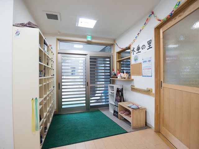 エントランスの靴箱と案内板 玄関 清潔感のあるエントランスでは、来訪者の靴を整理できる収納スペースが確保されており、掲示物から情報を得ることもできます。