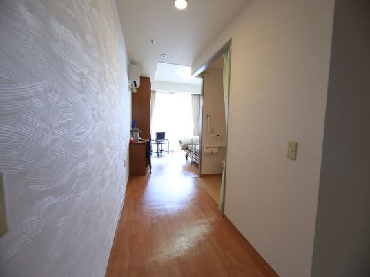 日当たりの良いワンルームの居室。通路部分にはトイレが設置されており、カーテンで仕切って使用するようになっている。