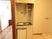 居室内に小型のキッチンが用意されている。流しの横にIHコンロがあり、その下に１人暮らしサイズの冷蔵庫が設置されている。