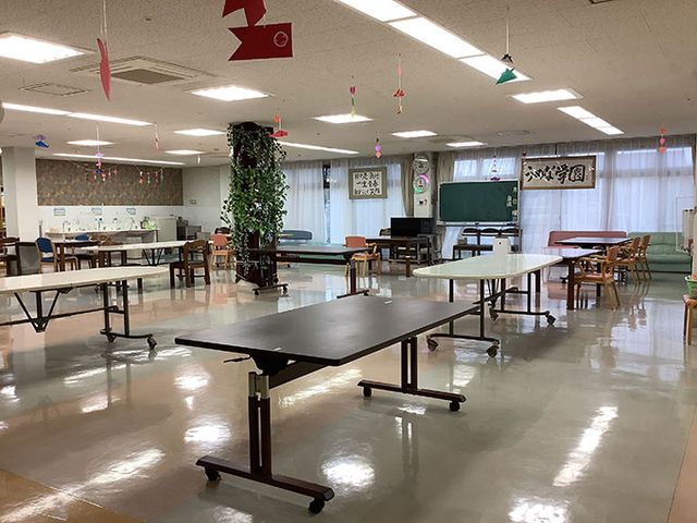 広々としたダイニングルーム ダイニングルーム 周囲はゆとりをもって配置されたテーブルと椅子が整然と並べられた食堂です。窓からは自然光が差し込み、居心地の良い空間を演出しています。