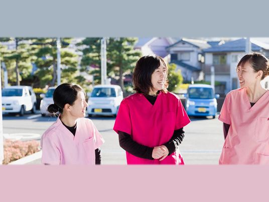 笑顔のスタッフが外で会話する外観  