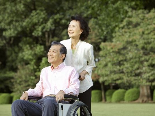車椅子の男性と立つ女性